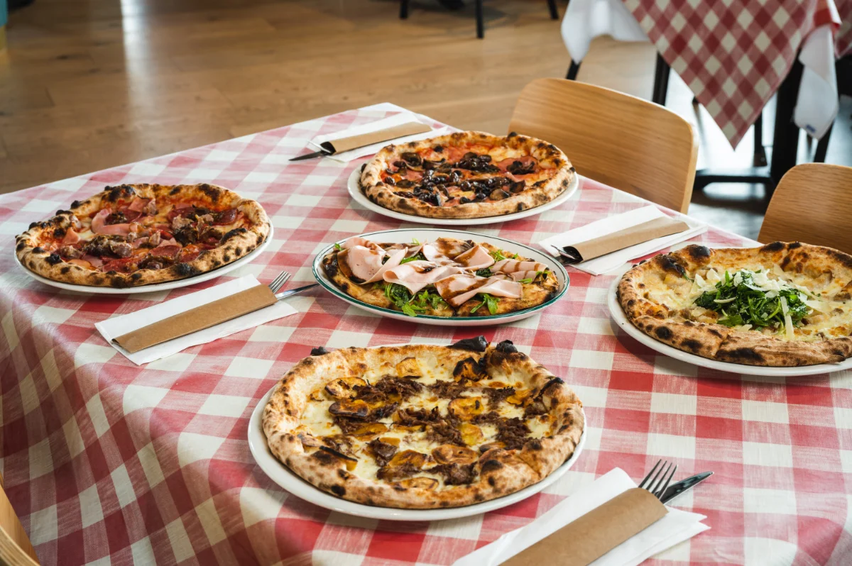 five Italian pizzas on a table
